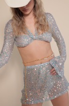 Gold and pearl belly chain paired with mermaid sequin twist top and mini skirt.
