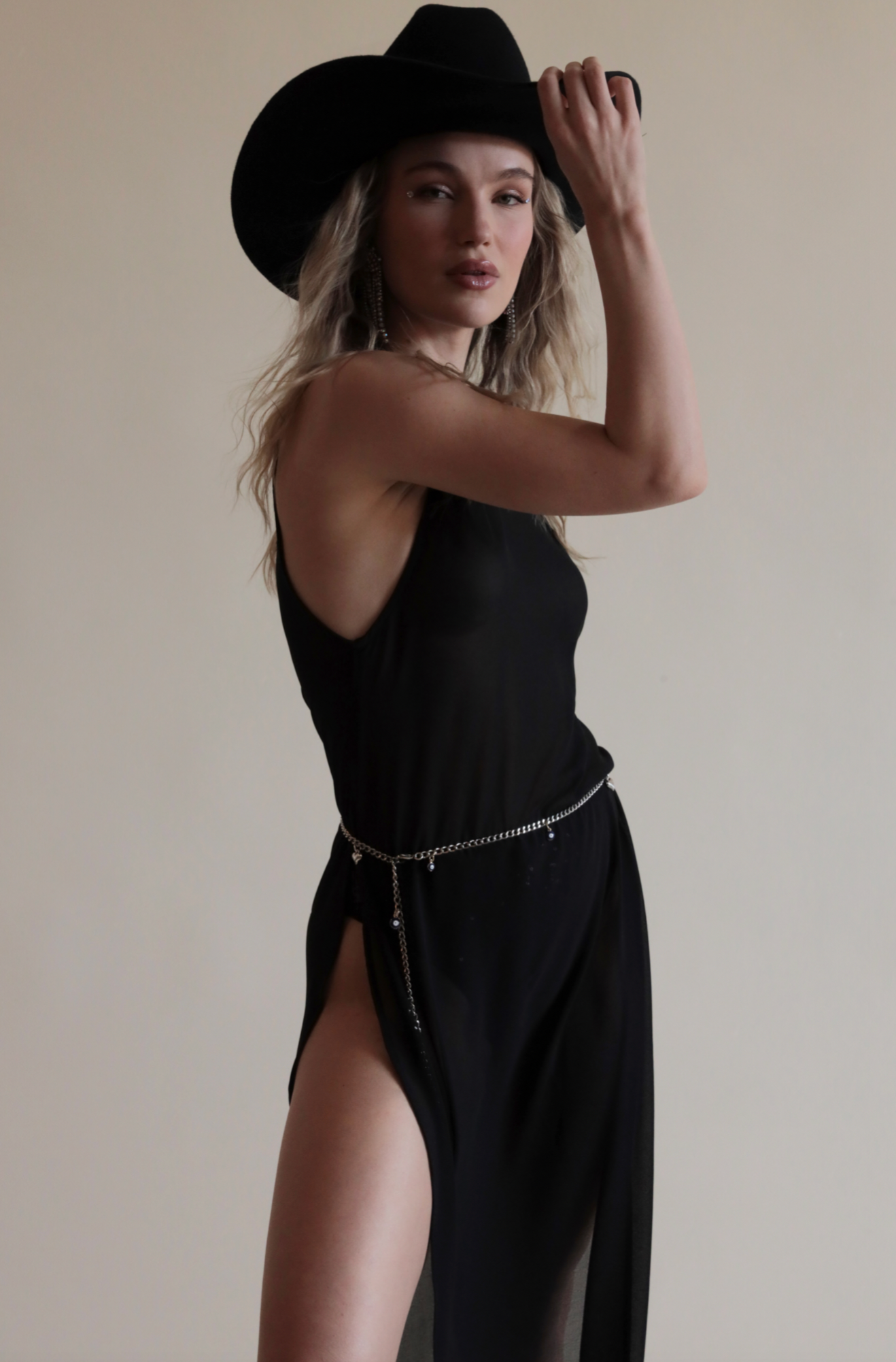 Black sheer maxi top with high neckline and ultra high slits on each side paired with silver belt.