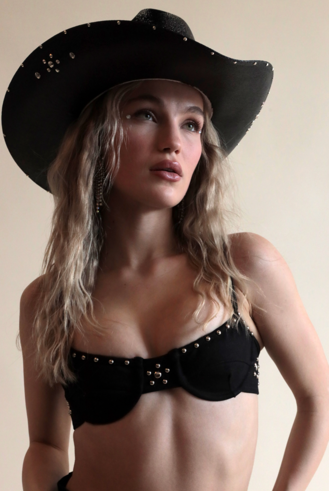 Black cowboy hat with metallic jewels paired with denim grommeted bra.