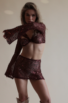 Red Twisted Top in Sequin Net and matching mini skirt.