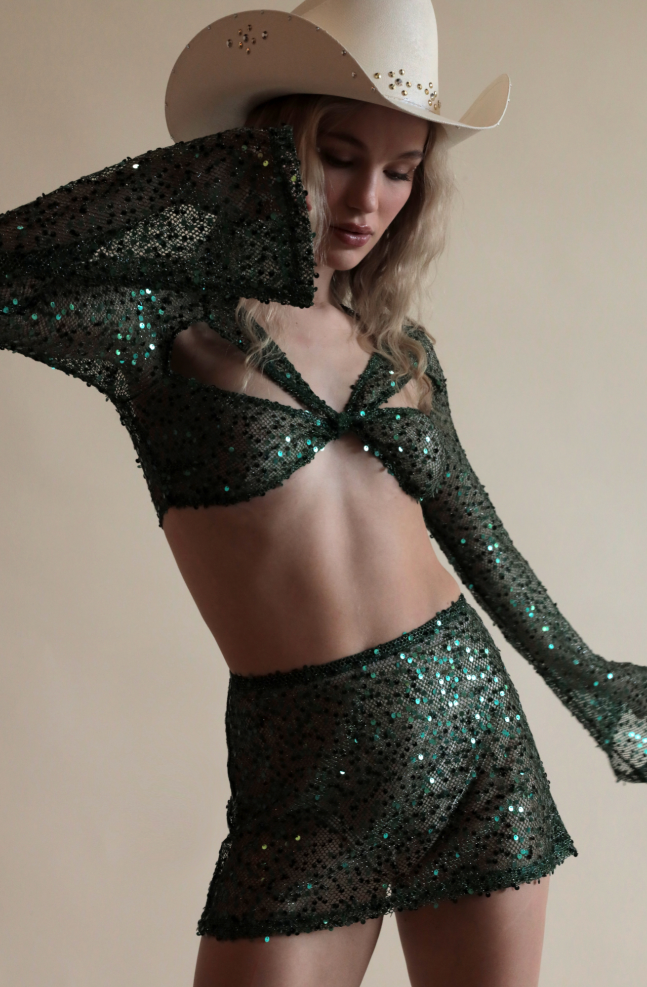 Green Twisted Top in Sequin Net and matching skirt paired with cowboy hat.