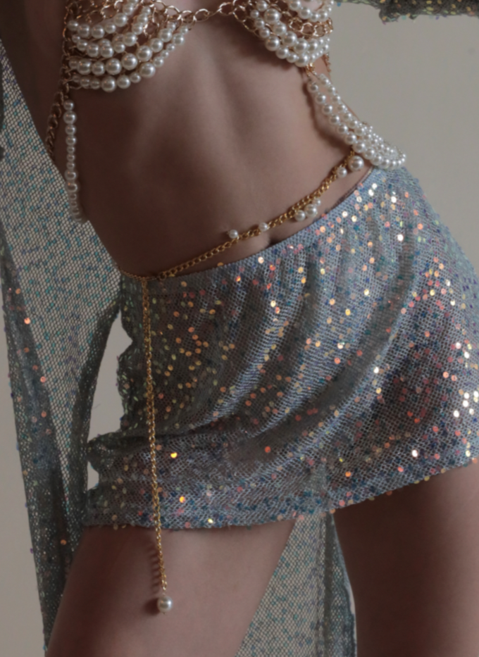 Gold and pearl belly chain paired with matching bra, mermaid sequin mini skirt, and mermaid sequin duster.